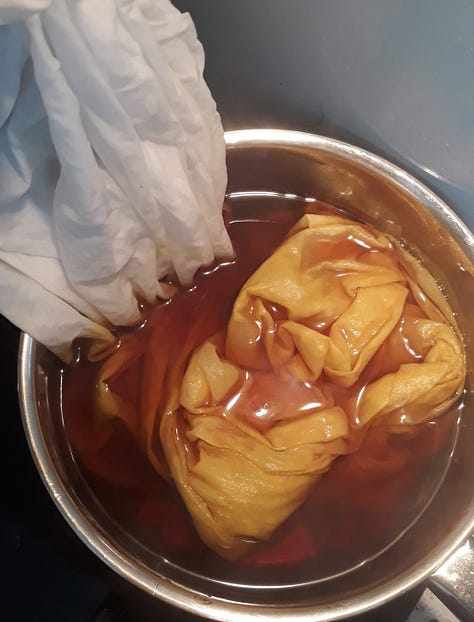 The marigolds bright orange in the pot, the white fabric lowered into the pot and dyed bright orange, the fabric after being fully submerged with a final mustardy yellow result