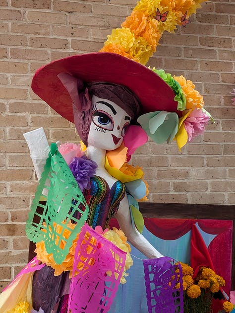 Colorful Day of the Dead altar with candles, flowers, and offerings.