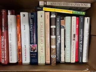 A selection of books in nine images. Each image has several books all lined up together in a row. One is a top-down look at four books that features their covers instead of their spines. Titles include:  W.E.B. Du Bois' "The Philadelphia Negro," "Between Past and Future" and "Human Condition" by Hannah Arendt, "Middle Passages: African American Journeys to Africa," 1787-2005," Michael Eric Dyson's "Holler If You Hear Me," and "City Schools and the American Dream: Reclaiming the Promise of Public Education" by Pedro A. Noguera and James A. Banks