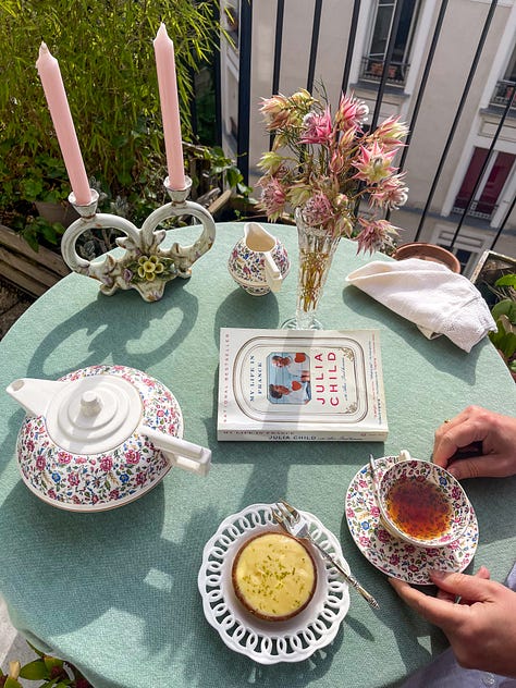 A gallery of creative settings in France. Varying tablescapes at teatime and holiday dinner, pastries and bonbons with pink flowers, watercolor paints, French bread and cheese with an inspiring book