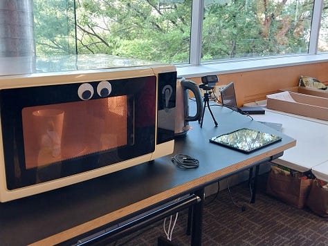 A toaster and microwave with microphones, and a knife block with googly eyes and a 'mouth' open for screaming