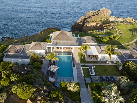 Aerial view of The Dunes in St. Barths, showcasing its vast estate with two infinity pools, lush tropical gardens, and modern architecture, all nestled near the secluded Saline Beach. The villa’s expansive terraces offer panoramic views of the Caribbean Sea, and the private, elegant interiors provide the ultimate in luxury and comfort.