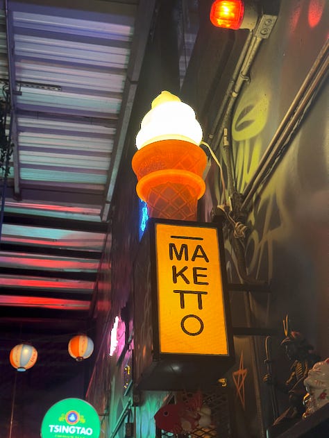 Sutorīto Māketto is a small space decorated with plants, neon signs, and graffiti.
