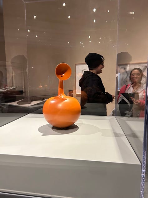 Musuem displays of pottery in glass cases, crafted headgear and 