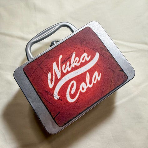 Silver lunchbox with nuka cola stickers