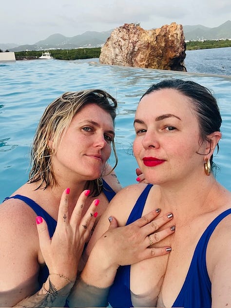 Three photos. From left to right: 1. Amber Tamblyn and Eliza Clark pose together in the pool for a selfie. They both look into the camera with slight, coy smiles. 2. Amber Tamblyn and Eliza Clark pose in the pool together for a selfie. Eliza has her arms around Amber. They both look at the camera with their mouths open, making surprised/excited faces. 3. Amber Tamblyn takes a selfie of her and Eliza Clark in the pool. Eliza is behind Amber making a kissy face with pursed lips. Amber is laughing.