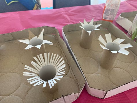 Photos of cardboard tubes snipped at the ends to create flower shapes ready to dip into paint