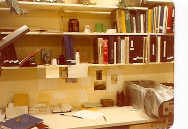 Yellowed photos of a laboratory bench with shelves full of books, vials full of chemicals, etc. Also a picture of a very handsome woman with her hair in braids, smiling at the camera. 