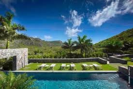 Aerial view of The Dunes in St. Barths, showcasing its vast estate with two infinity pools, lush tropical gardens, and modern architecture, all nestled near the secluded Saline Beach. The villa’s expansive terraces offer panoramic views of the Caribbean Sea, and the private, elegant interiors provide the ultimate in luxury and comfort.