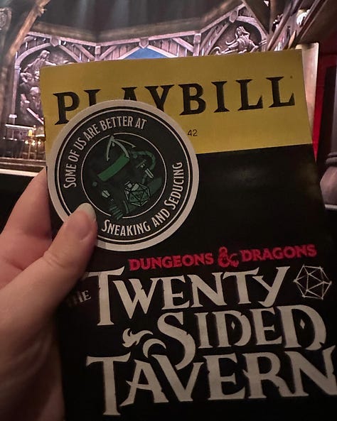 The program for Twenty-Sided Tavern | A table with mythological-themed props | A cup of cider in front of a beautiful mountain landscape