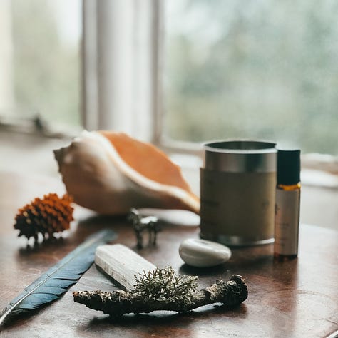 1. Circle centrepiece with a log, flowers, shells and a candle. 2. A small altar with a large shell, a candle in a tin, pinecone, feather, selenite crystal, moss stick and a stone. 3. A hand with a lotus tatoo at the wrist holding a small white bowl with dried rose petals, small shell, ceramic butterfly and pinecone.