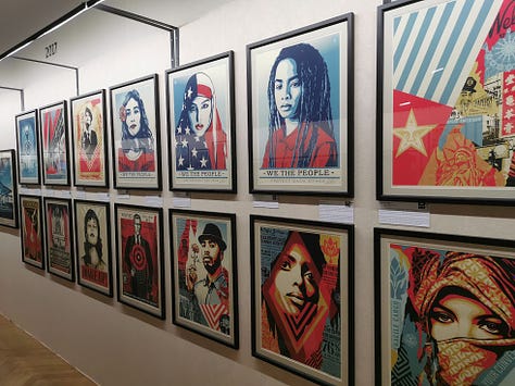 Photos of Shepard Fairey silkscreen prints in a large exhibition hall