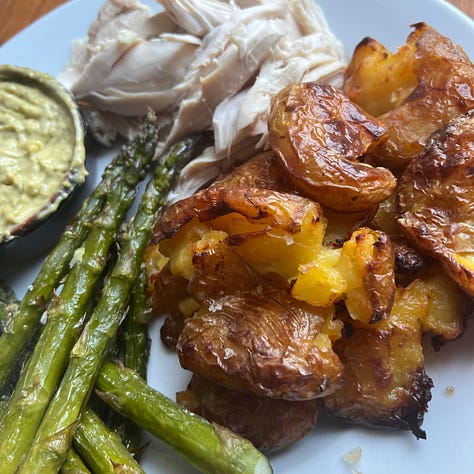 An asparagus tart, asparagus and crumbled Parmesan, asparagus, crispy smashed potatoes and green dip