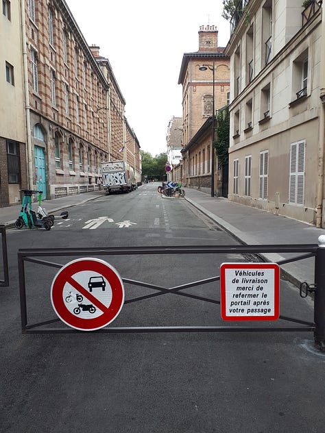 A street closed off to vehicles with railings.