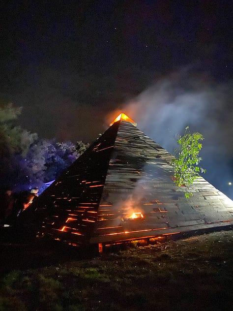 Series of images of large timber pyramid structure in open space as fire takes hold and it burns to the ground