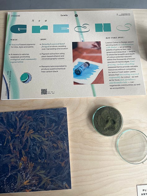 1-3. Exhibition table for 'greens' showing Phoebe Lewis' artefacts for using seaweed to create dye pigments, with vials of liquid, dried pigment and a paint sample.