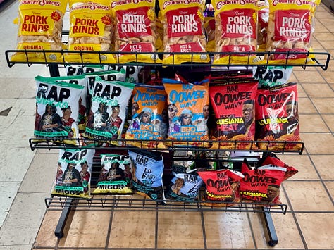 Shelves of hair-care products, hip-hop themed chips, and meals in a box.