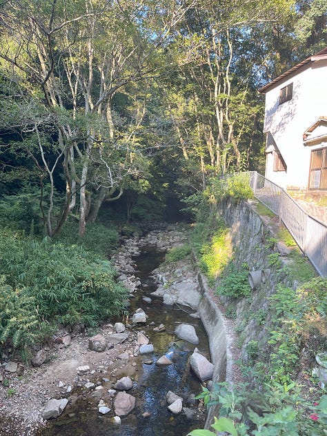 Pictures of riverside, a train leaving a small station, a passageway so small it looks like a culvert, and the suburbs of Kobe