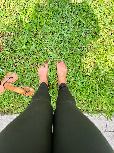 selfie photo of woman smiling in her apartment; selfie photo of three friends under a beach umbrella; photo of a beagle-King Charles Cavalier Spaniel mix dog looking down at the floor, taken from dog's eye level; photo of the photographer's legs and bare feet standing on thick, green blades of grass; photo of a microphone and computer screen with recording software; photo of a black and white cat lounging on a paved path of lush garden in the backyard of a building; photo of sunset at the beach with rays of pink and white and blue light over the horizon above the water; photo of cars driving in heavy traffic on a highway with billboards and buildings in the distance and white and gray clouds in the foreground and a clear blue sky in the background; wide-angle photo of a wide tan beach with the ocean in the far distance and a blue sky with white and gray swirling clouds above and a wide double rainbow over the shoreline.