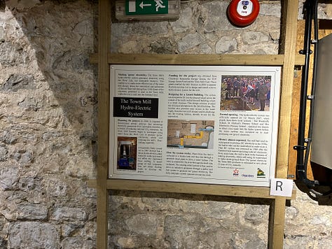 10 photographs showing the inside of Town Mill, Lyme Regis. The milling is done on two floors. On the upper floor the grain is poured into the hopper from where it falls by vibration and gavity down to the millstones below. The grain is then ground and falls into the waiting bag. Flour is sold at the mill and one photo shows bags of flour in plain brown paper bags. Images: Roland's Travels