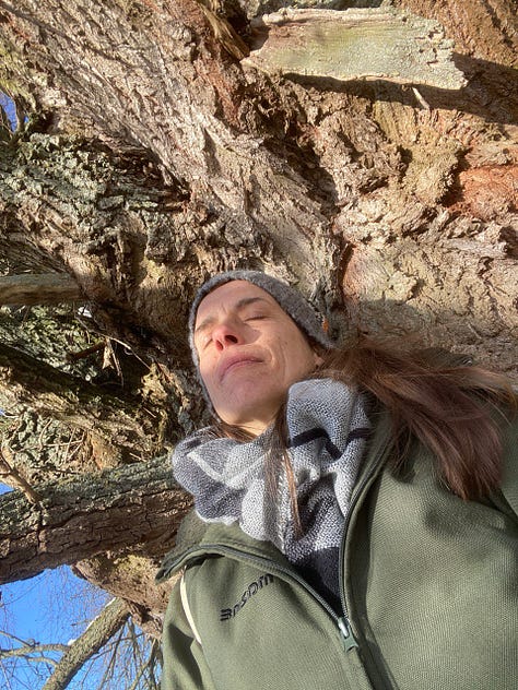 Kath leaning on to the trunk of her beloved Willow tree friend