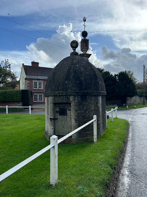 Three photos showing Steeple Ashtom Market Cross and Lock-up from different angles. They are situated on one corner of the village green. Images: Roland's Travels