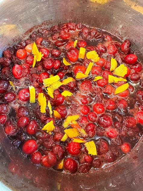 cranberries in a sauce pan cooking and then canned ready for Thanksgiving