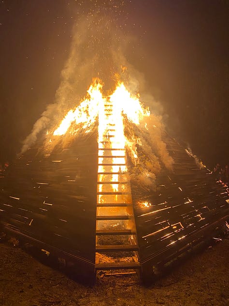 Series of images of large timber pyramid structure in open space as fire takes hold and it burns to the ground