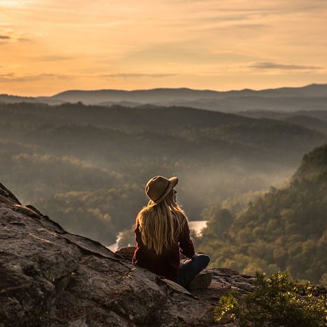 autumn trees, birds flying above trees, woman viewing mountain tops