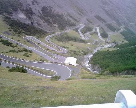 Top L: the road down the Stelvio Pass, cows in a summer Alpine snow storm, wildflowers in Valemalenco, bed stones warming on the fire at a rifugio, spying a stambeco (mountain goat) on a high ridge at 3000m+, skiing in Bormio, snow like thick icing in Madesimo, Alpine peaks and piste Madesimo, me with a hot bedstone to warm my feet 