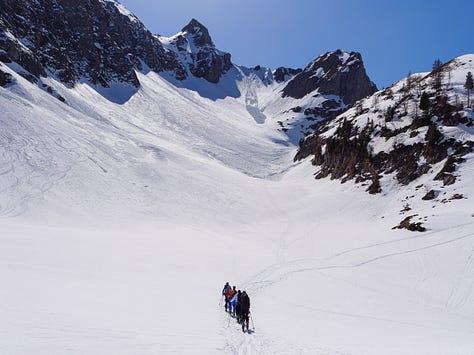 Images of people on ski tour, skinning up in a line behind each other.