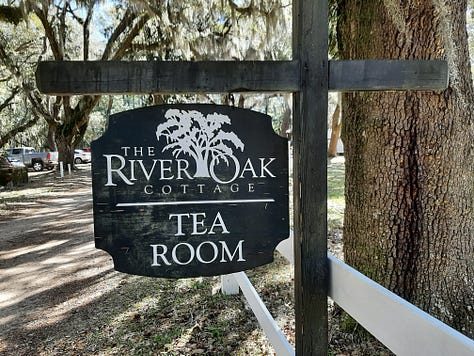 A sign showing River Oak Cottage Tea Room, along with a picture of a fireplace and bookcase and large tour with red Oriental rug. The last picture is white round tables and chairs with blue tablecloths and dinnerware.