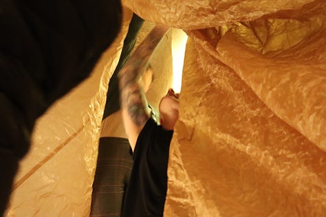 A large underground crypt transformed into an organ of healing via installation of waxed kraft paper environment and performances held in the space. 