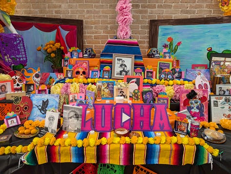 Colorful Day of the Dead altar with candles, flowers, and offerings.