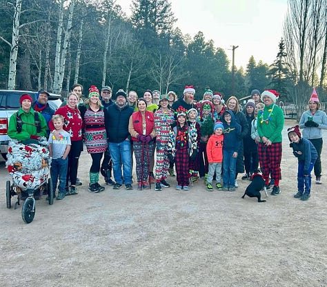 finish line posing photo, an older woman in a blue shirt holds a medal, and a group of people in christmas pajamas pose in the park, fun run, Cloudcroft, New Mexico