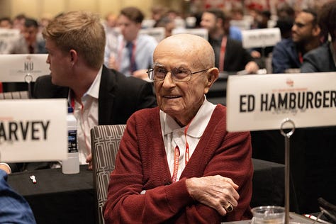 Ed smiling in 3 photos: one wearing medals and with a trophy in background, one in a large meeting, and one on stage being recognized by 2 other men