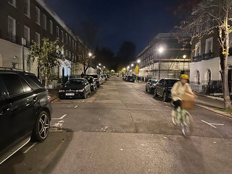 A variety of pictures of London streets at night. One shows a bus stop with people waiting at it. Another a bike locker and other bike parking. Another shows a van and car for hire. The rest show street scenes with Georgian town houses and empty streets lit by street lights