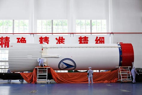 The third-stage of the rocket undergoing hardware installation, one of the boosters being lifted during stacking, and the first and second stages ahead of pre-launch operations on the launch pad.