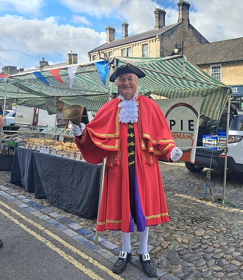 Barnard Castle farmers market; customers, dogs, Town Crier