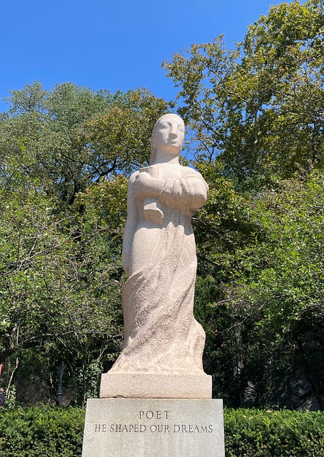 large limestone sculptures in an outdoor sculpture garden against a blue sky depicting a laborer, a scientist, and a poet