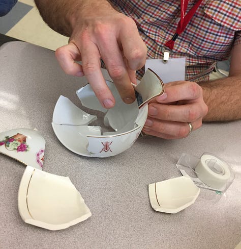 broken cups and plates are sorted and reassembled using wax, tape and fiber
