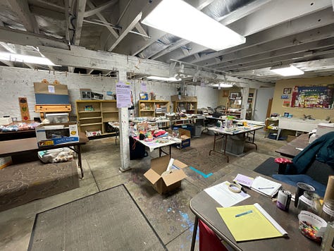 Swap tubs in a retail store, empty tables arranged in a basement, the same tables beginning to fill with materials, and a wide range of donated supplies on those tables from paint to frames.