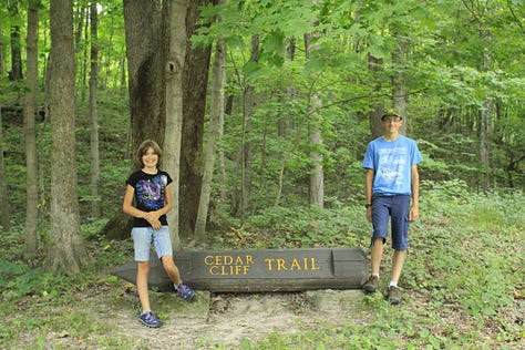 Photos of a heavily wooded trail with two people hiking and posing along the trail