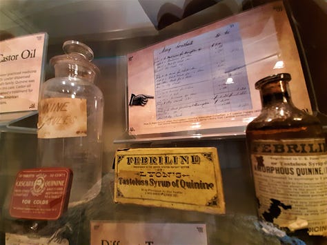 Original medicines in their bottles and a small sign that sits beside the jar of leeches.