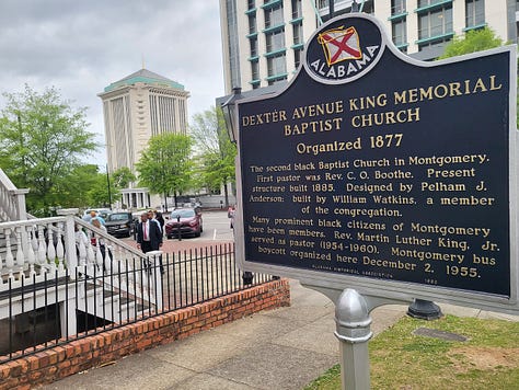 Bronze of Rosa Parks, historic marker by MLK's Dexter Avenue Baptist Church, names of justice nonprofits etched into a black wall, tomb-like structures listing those killed by lynching, shown laying like a coffin and hanging above