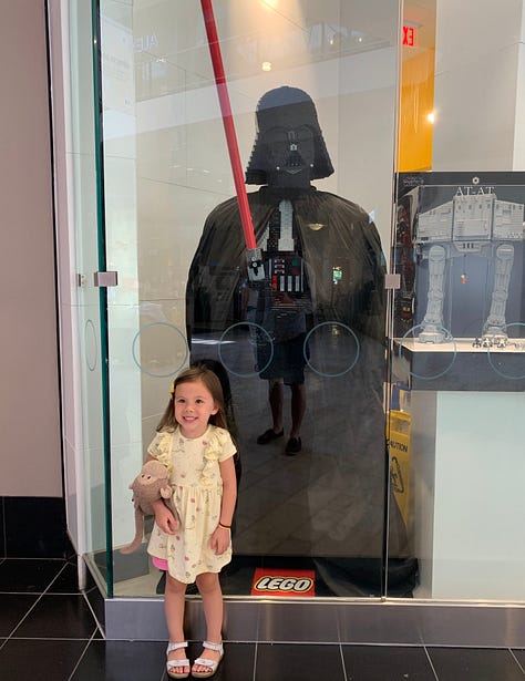 My daughter, Hannah, enjoying Star Wars Golden books, and Darth Vader Legos
