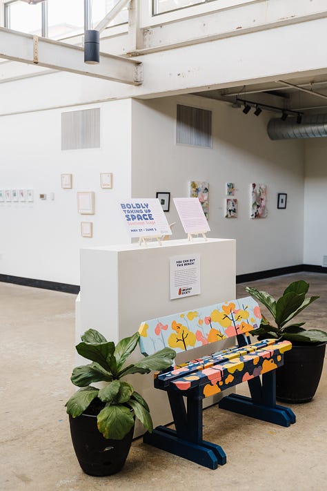 A series of images showing a brightly lit gallery interior with a concrete floor and high ceilings. Various people are gathered around podiums and a colorfully-painted park bench. It is inviting and spacious, with framed artworks on the walls, green broad leaf plants and a few easels displaying signage about the work. 