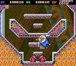 A series of screenshots from the arcade version of Snow Bros. The first depicts the blue face characters you need to defeat in order to spell out "snow" and earn an extra life. They're on screen with a number of standard foes. The second screenshot shows an encounter against the game's first boss, which is a massive lizard-y man who summons smaller enemies to defeat you, which you then turn into snowballs and fire off at him. The third shows the power-up that massively increases your size, as that version of the character flies right into an enemy for a much higher point total than normally defeating them would grant.