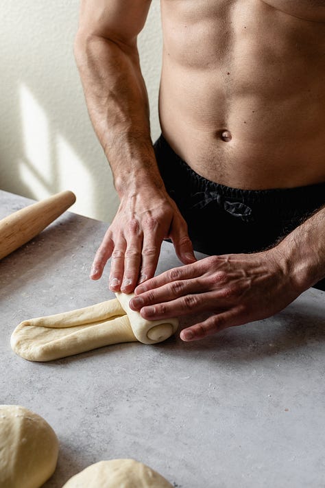 Shirtless baker in black pants making vegan milk bread loaves