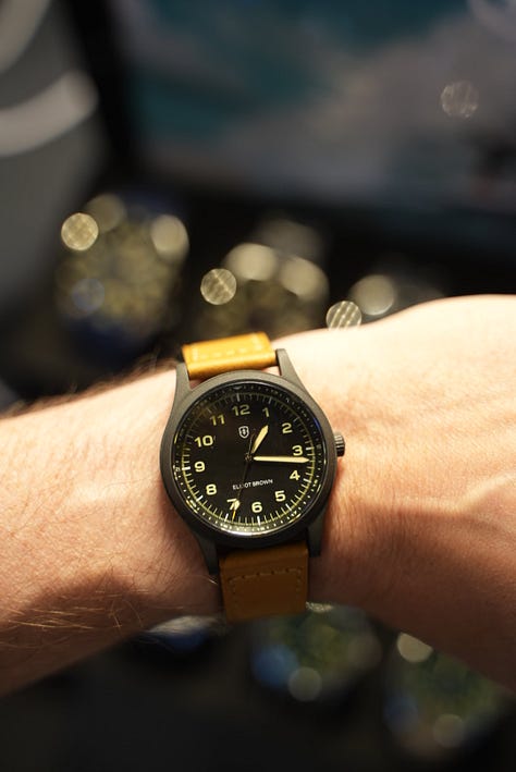 Beachmaster on wrist, with Gem holding a coctail, a display of the watch models made by EB, and a black PVD coated Arne